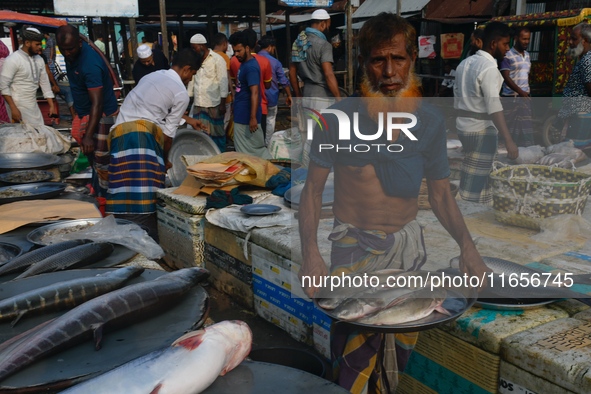 People gather at a wholesale fish market early in the morning near the Padma River in Mawa, Munshiganj, Bangladesh, on October 11, 2024. The...