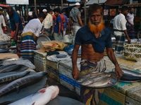 People gather at a wholesale fish market early in the morning near the Padma River in Mawa, Munshiganj, Bangladesh, on October 11, 2024. The...