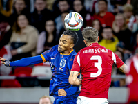 Netherlands midfielder Quinten Timber and Hungary midfielder Tamas Nikitscher play during the match between Hungary and the Netherlands at t...