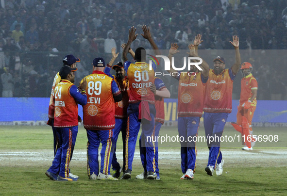 Kevon Cooper (C) is congratulated by teammates after claiming a hat-trick during the Legends League Cricket T20 match between Gujarat Greats...