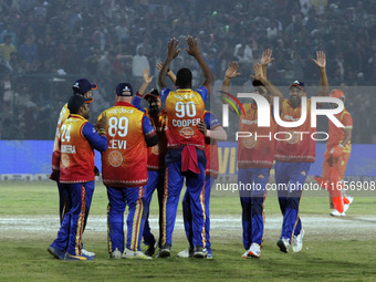 Kevon Cooper (C) is congratulated by teammates after claiming a hat-trick during the Legends League Cricket T20 match between Gujarat Greats...