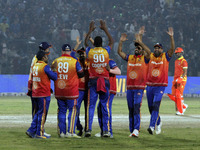 Kevon Cooper (C) is congratulated by teammates after claiming a hat-trick during the Legends League Cricket T20 match between Gujarat Greats...