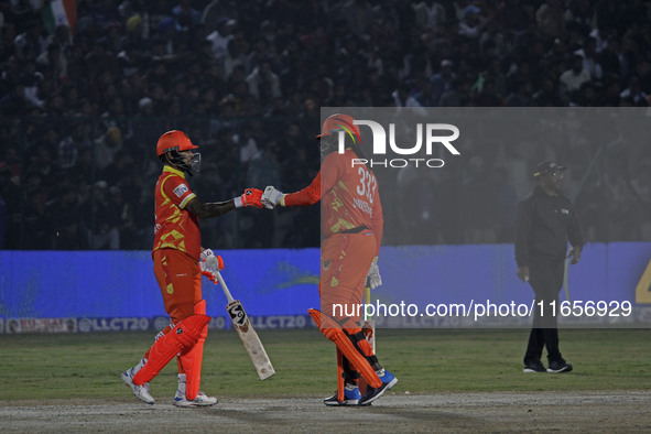 Chris Gayle (R) and Shikhar Dhawan (L) of Gujarat Greats participate in the Legends League Cricket T20 match between Gujarat Greats and Kona...