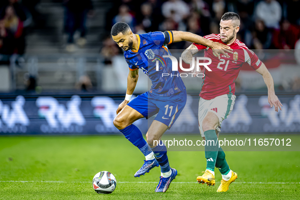 Netherlands forward Cody Gakpo and Hungary defender Endre Botka play during the match between Hungary and the Netherlands at the Puskas Aren...