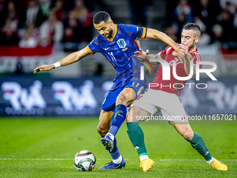 Netherlands forward Cody Gakpo and Hungary defender Endre Botka play during the match between Hungary and the Netherlands at the Puskas Aren...