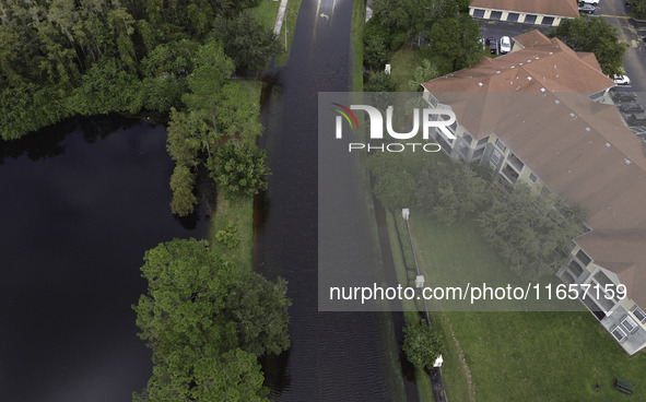 The street floods during Hurricane Milton in the Hunters Creek region, Florida, with water trapped between residents' homes and the lake, on...