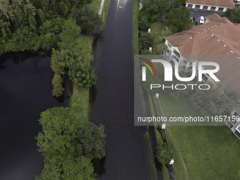 The street floods during Hurricane Milton in the Hunters Creek region, Florida, with water trapped between residents' homes and the lake, on...