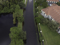 The street floods during Hurricane Milton in the Hunters Creek region, Florida, with water trapped between residents' homes and the lake, on...