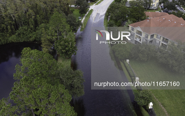 The street floods during Hurricane Milton in the Hunters Creek region, Florida, with water trapped between residents' homes and the lake, on...