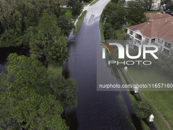 The street floods during Hurricane Milton in the Hunters Creek region, Florida, with water trapped between residents' homes and the lake, on...