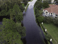 The street floods during Hurricane Milton in the Hunters Creek region, Florida, with water trapped between residents' homes and the lake, on...