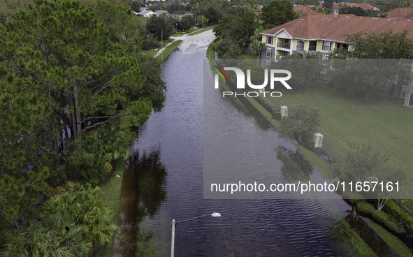 The street floods during Hurricane Milton in the Hunters Creek region, Florida, with water trapped between residents' homes and the lake, on...