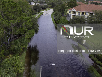 The street floods during Hurricane Milton in the Hunters Creek region, Florida, with water trapped between residents' homes and the lake, on...