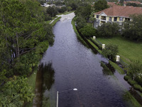 The street floods during Hurricane Milton in the Hunters Creek region, Florida, with water trapped between residents' homes and the lake, on...