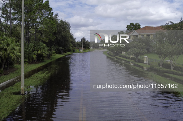 The street floods during Hurricane Milton in the Hunters Creek region, Florida, with water trapped between residents' homes and the lake, on...