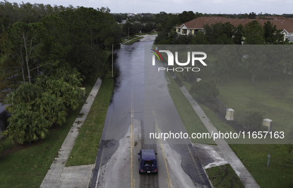 The street floods during Hurricane Milton in the Hunters Creek region, Florida, with water trapped between residents' homes and the lake, on...