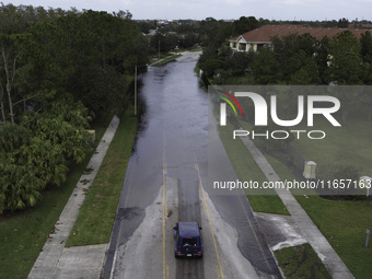 The street floods during Hurricane Milton in the Hunters Creek region, Florida, with water trapped between residents' homes and the lake, on...