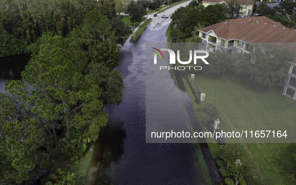 The street floods during Hurricane Milton in the Hunters Creek region, Florida, with water trapped between residents' homes and the lake, on...