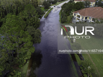 The street floods during Hurricane Milton in the Hunters Creek region, Florida, with water trapped between residents' homes and the lake, on...