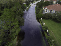 The street floods during Hurricane Milton in the Hunters Creek region, Florida, with water trapped between residents' homes and the lake, on...