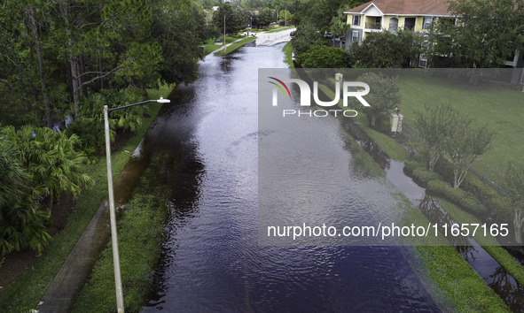 The street floods during Hurricane Milton in the Hunters Creek region, Florida, with water trapped between residents' homes and the lake, on...