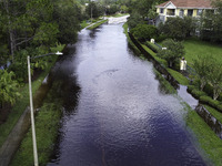 The street floods during Hurricane Milton in the Hunters Creek region, Florida, with water trapped between residents' homes and the lake, on...