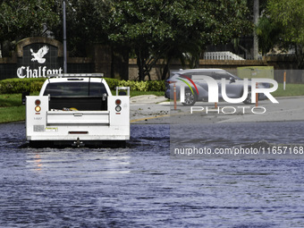 The street floods during Hurricane Milton in the Hunters Creek region, Florida, with water trapped between residents' homes and the lake, on...