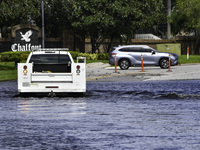 The street floods during Hurricane Milton in the Hunters Creek region, Florida, with water trapped between residents' homes and the lake, on...