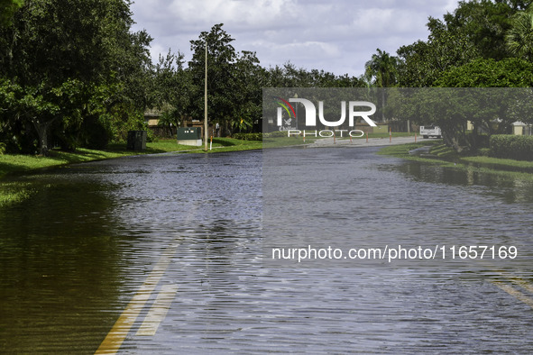 The street floods during Hurricane Milton in the Hunters Creek region, Florida, with water trapped between residents' homes and the lake, on...