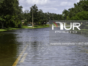 The street floods during Hurricane Milton in the Hunters Creek region, Florida, with water trapped between residents' homes and the lake, on...