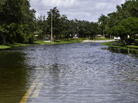 The street floods during Hurricane Milton in the Hunters Creek region, Florida, with water trapped between residents' homes and the lake, on...