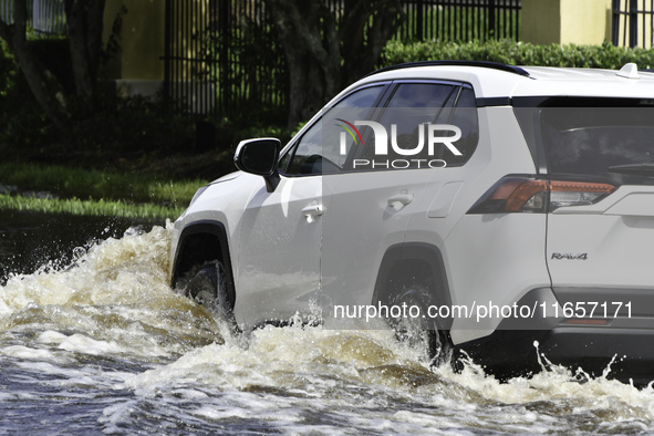 The street floods during Hurricane Milton in the Hunters Creek region, Florida, with water trapped between residents' homes and the lake, on...