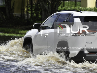 The street floods during Hurricane Milton in the Hunters Creek region, Florida, with water trapped between residents' homes and the lake, on...