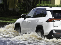 The street floods during Hurricane Milton in the Hunters Creek region, Florida, with water trapped between residents' homes and the lake, on...