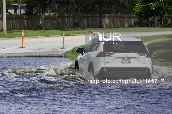 The street floods during Hurricane Milton in the Hunters Creek region, Florida, with water trapped between residents' homes and the lake, on...