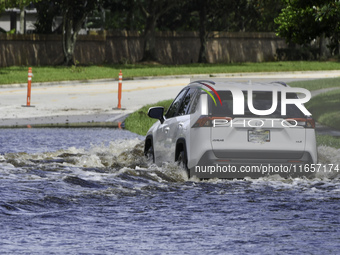 The street floods during Hurricane Milton in the Hunters Creek region, Florida, with water trapped between residents' homes and the lake, on...