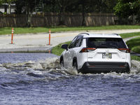 The street floods during Hurricane Milton in the Hunters Creek region, Florida, with water trapped between residents' homes and the lake, on...