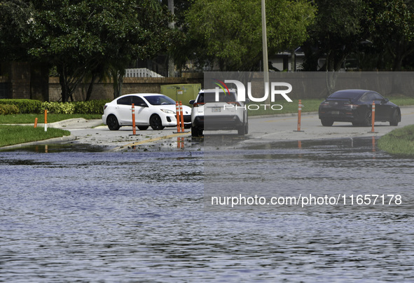 The street floods during Hurricane Milton in the Hunters Creek region, Florida, with water trapped between residents' homes and the lake, on...