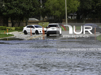 The street floods during Hurricane Milton in the Hunters Creek region, Florida, with water trapped between residents' homes and the lake, on...