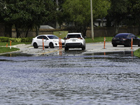 The street floods during Hurricane Milton in the Hunters Creek region, Florida, with water trapped between residents' homes and the lake, on...