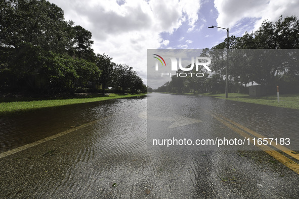 The street floods during Hurricane Milton in the Hunters Creek region, Florida, with water trapped between residents' homes and the lake, on...