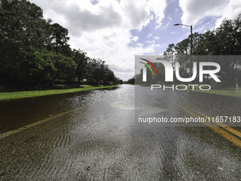 The street floods during Hurricane Milton in the Hunters Creek region, Florida, with water trapped between residents' homes and the lake, on...