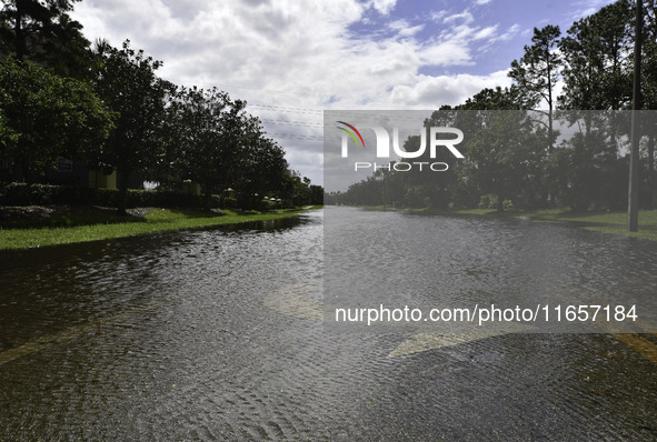 The street floods during Hurricane Milton in the Hunters Creek region, Florida, with water trapped between residents' homes and the lake, on...