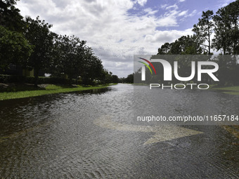 The street floods during Hurricane Milton in the Hunters Creek region, Florida, with water trapped between residents' homes and the lake, on...