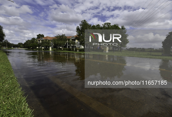 The street floods during Hurricane Milton in the Hunters Creek region, Florida, with water trapped between residents' homes and the lake, on...