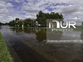 The street floods during Hurricane Milton in the Hunters Creek region, Florida, with water trapped between residents' homes and the lake, on...