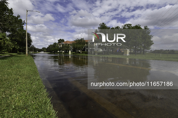 The street floods during Hurricane Milton in the Hunters Creek region, Florida, with water trapped between residents' homes and the lake, on...