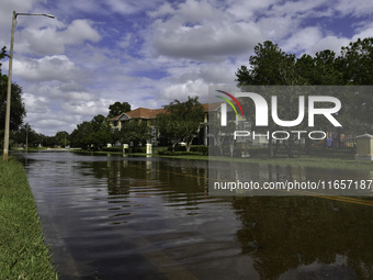 The street floods during Hurricane Milton in the Hunters Creek region, Florida, with water trapped between residents' homes and the lake, on...