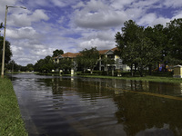 The street floods during Hurricane Milton in the Hunters Creek region, Florida, with water trapped between residents' homes and the lake, on...