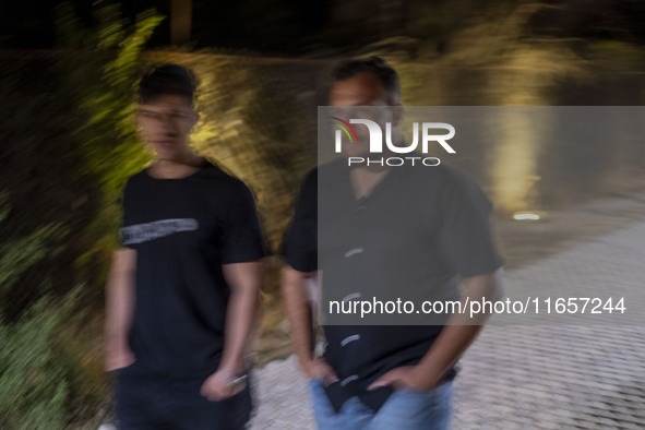 Iranian men walk along a path in the city of Shiraz in Fars province, about 932 km (579 miles) south of Tehran, Iran, at night on October 7,...